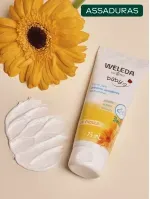 Weleda baby ao lado de girassol e um pouco de creme